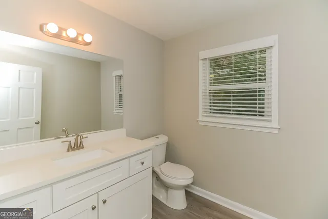 a bathroom with a toilet a sink a vanity and mirror