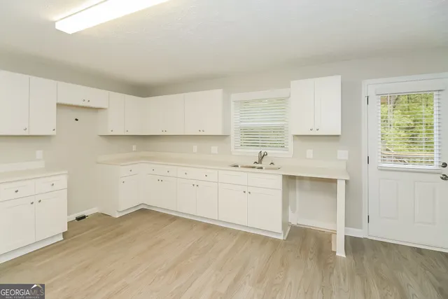 a kitchen with granite countertop white cabinets and white appliances