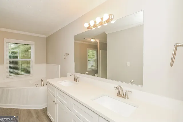 a bathroom with a sink a large mirror and a bathtub