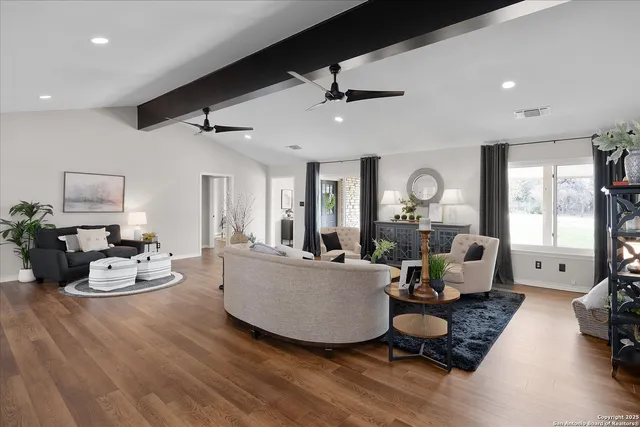 a kitchen with stainless steel appliances a stove a sink a microwave a dining table and chairs