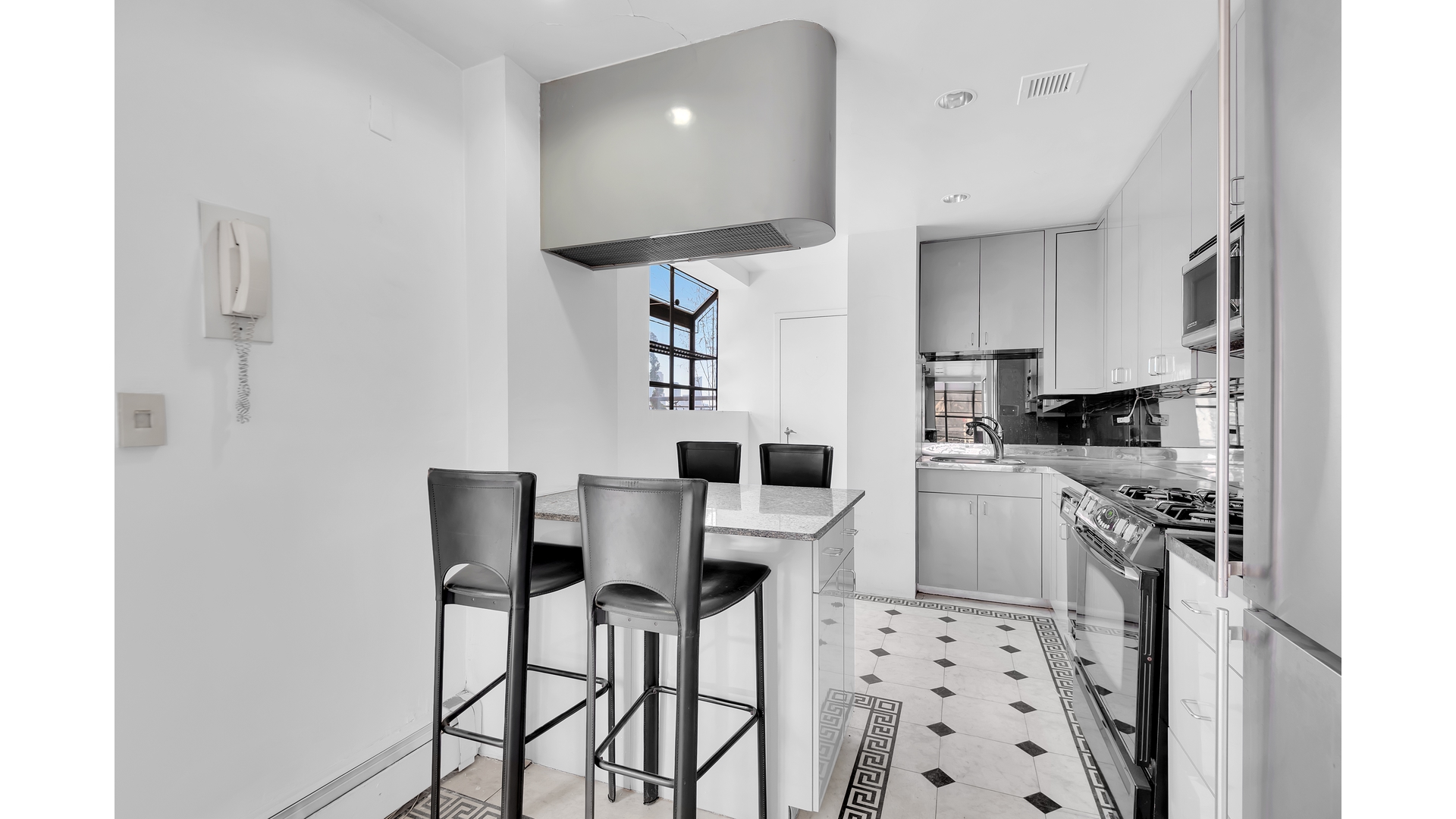 40 Sutton Place, Unit PHM Manhattan, NY 10022 - Photo 3 of 12 a kitchen with stainless steel appliances kitchen island granite countertop a refrigerator and a stove top oven
