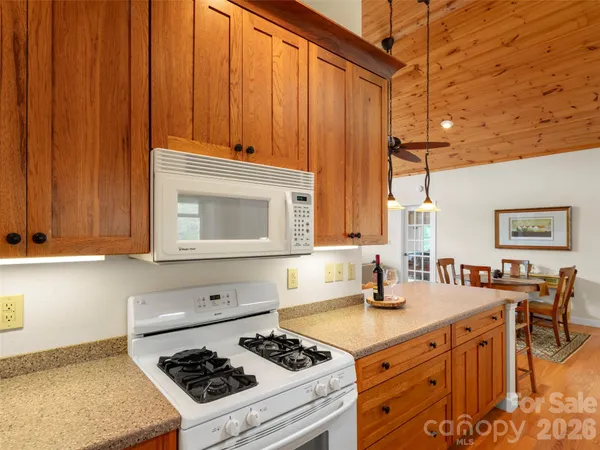 a kitchen with stainless steel appliances a stove a sink cabinets and a dining table