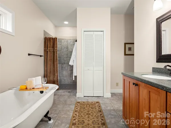 a bathroom with a granite countertop sink a mirror and a bathtub