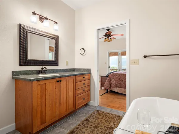 a en suite bathroom with a granite countertop sink and a mirror
