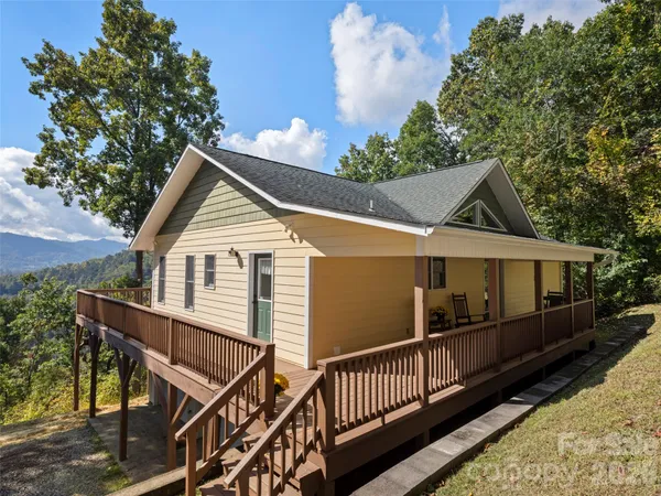 a view of house along with deck and outdoor seating