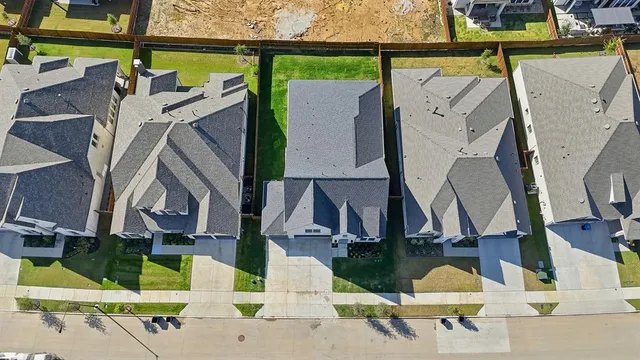 an aerial view of residential houses with outdoor space and swimming pool