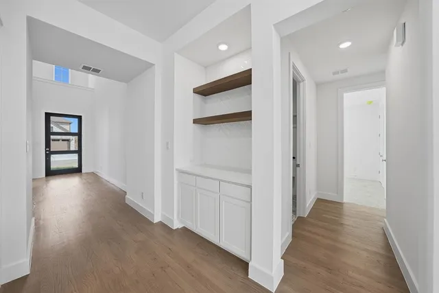 a view of a hallway with wooden floor and stairs