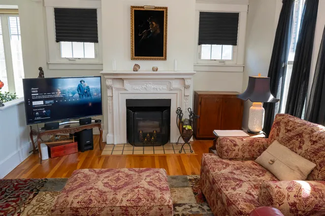 a living room with furniture a flat screen tv and a fireplace