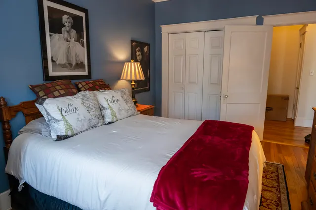 a bedroom with a bed and a painting on the wall