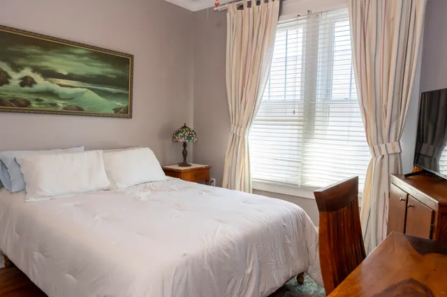 a bedroom with a bed and a painting on the wall