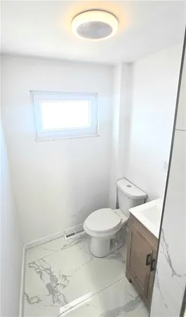 a bathroom with a toilet and a mirror