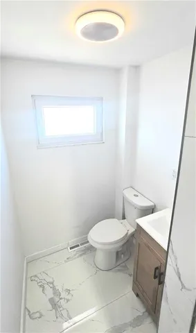 a bathroom with a toilet and a mirror
