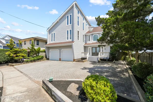 a living room with furniture kitchen view and a wooden floor
