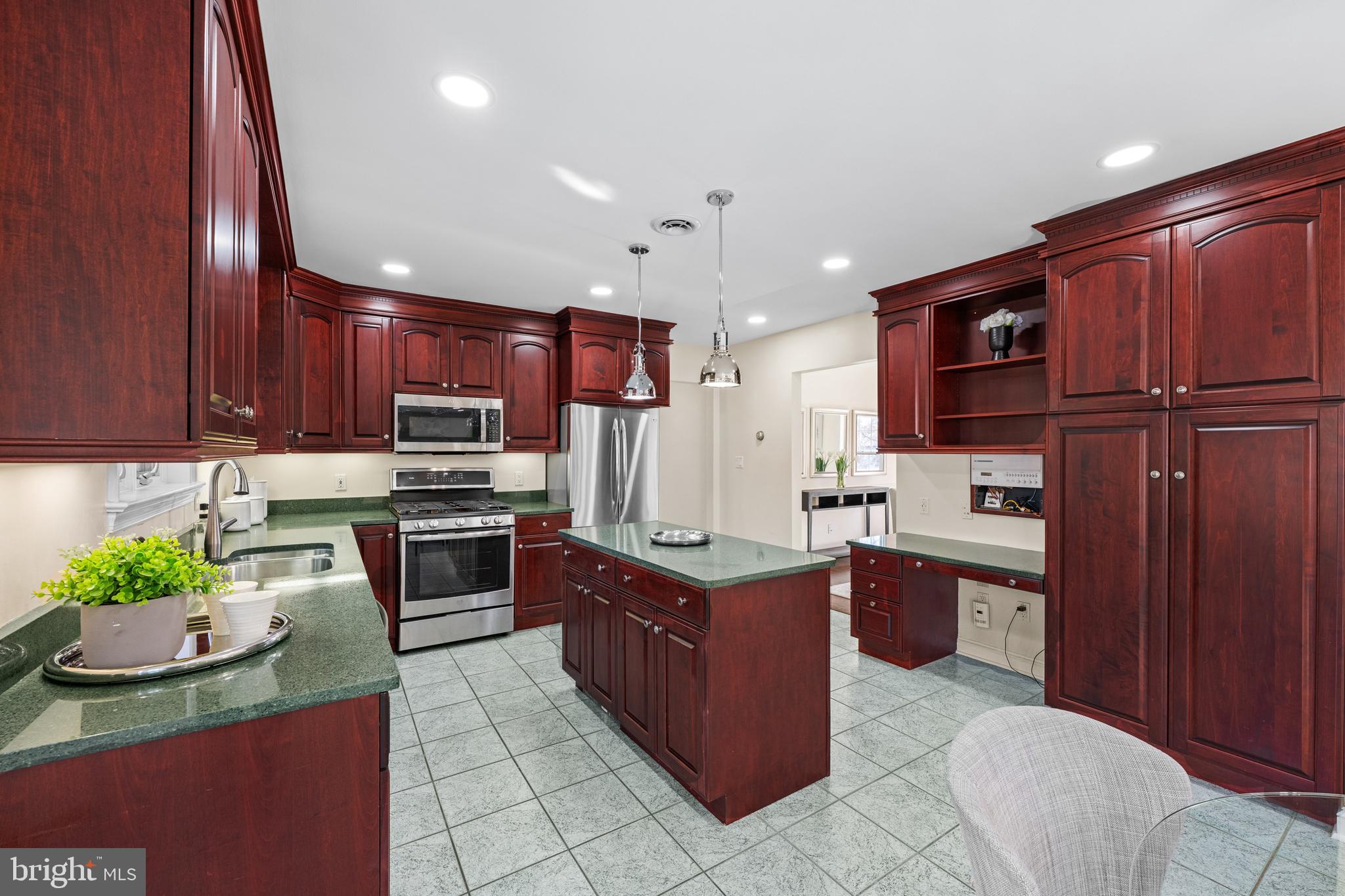 4807 Bready Road Rockville, MD 20853 - Photo 21 of 44 a kitchen with stainless steel appliances granite countertop wooden cabinets a stove top oven a sink and dishwasher