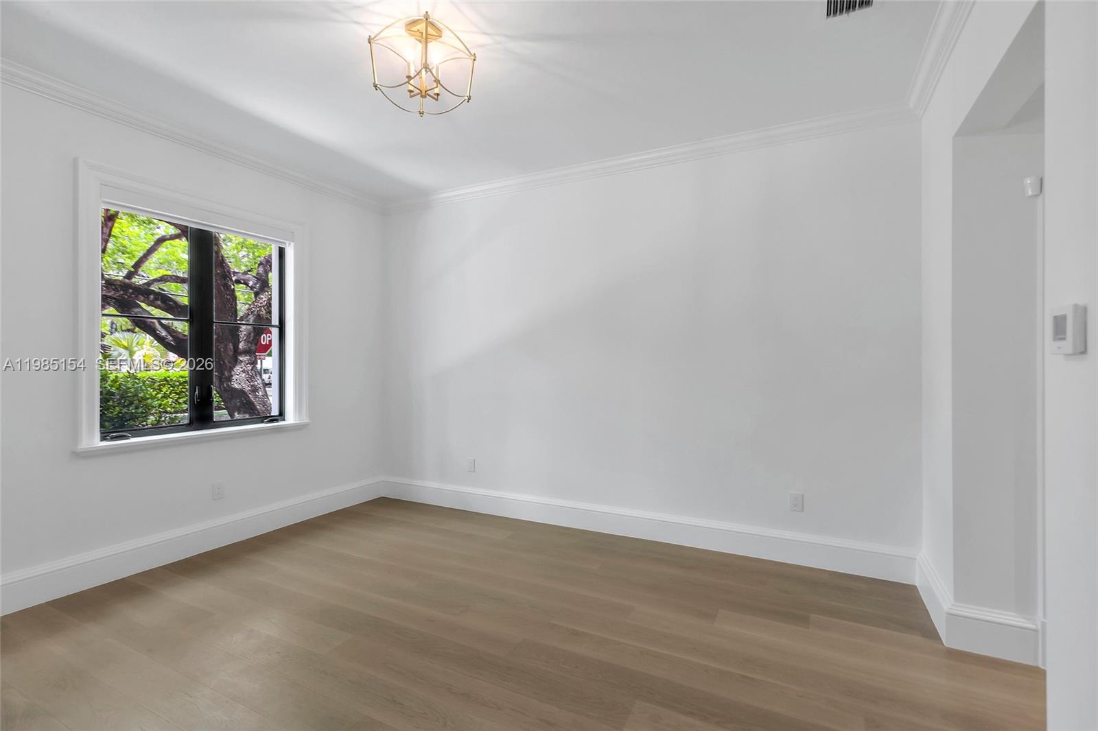 2613 Anderson Road, Unit 2613 Coral Gables, FL 33134 - Photo 13 of 96 a view of an empty room with wooden floor and a window