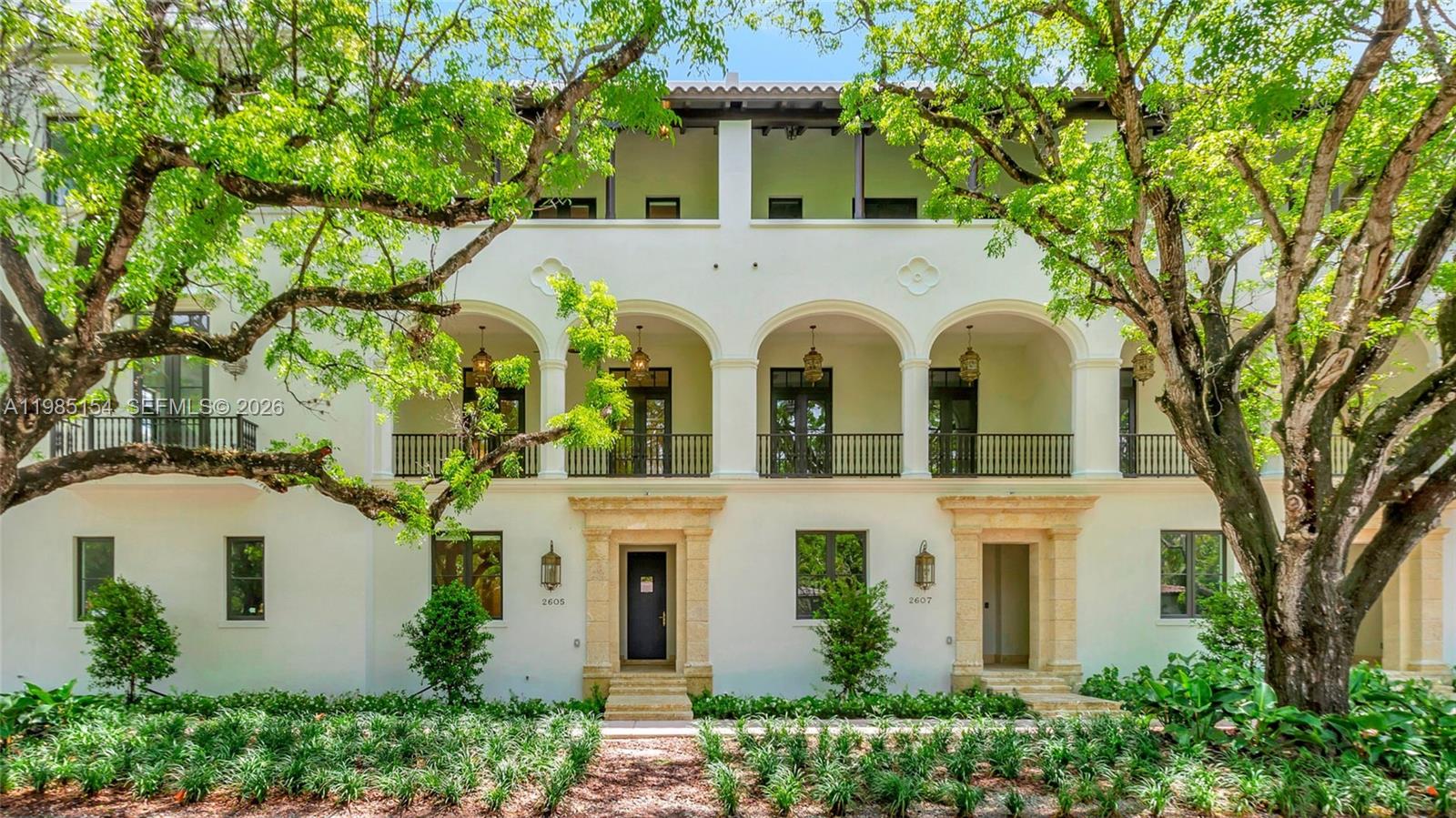 2613 Anderson Road, Unit 2613 Coral Gables, FL 33134 - Photo 2 of 96 a view of a white house with large windows and a large tree