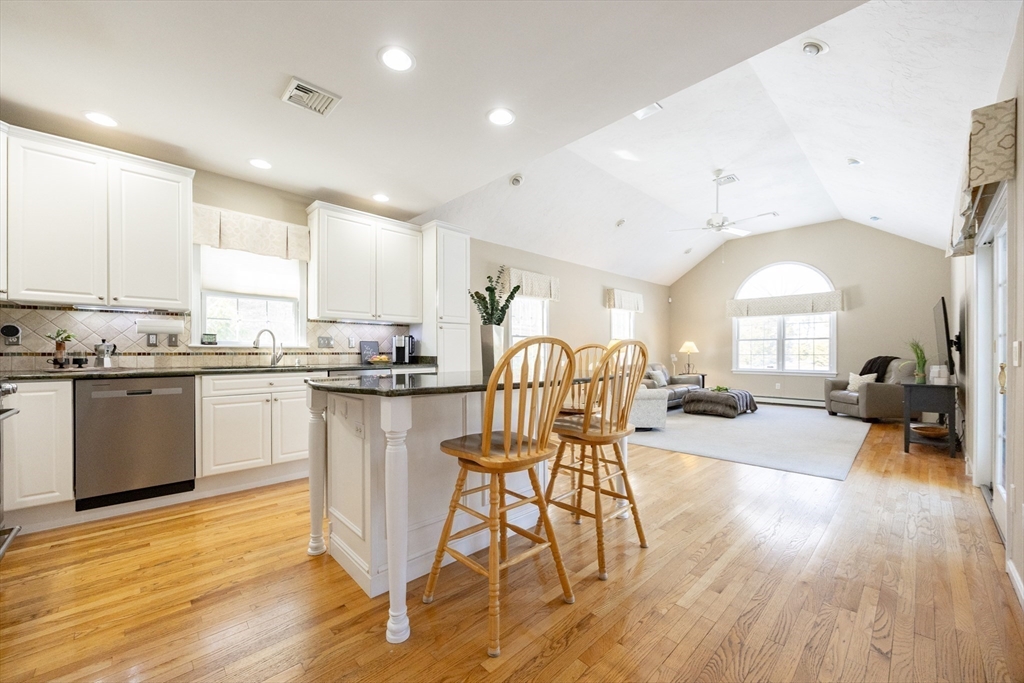 48 Laurel Drive Hudson, MA 01749 - Photo 14 of 42 a kitchen with stainless steel appliances a dining table chairs stove and cabinets
