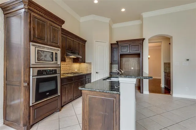 a kitchen with stainless steel appliances granite countertop a stove and a refrigerator