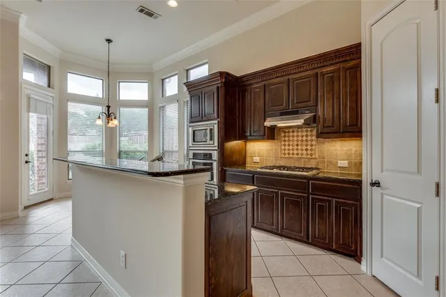 a kitchen with granite countertop a stove and a refrigerator