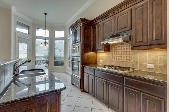 a kitchen with stainless steel appliances granite countertop a stove and a sink