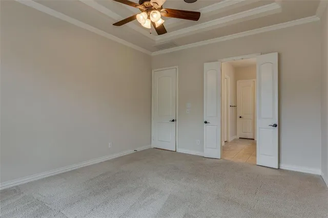 a view of an empty room and chandelier fan