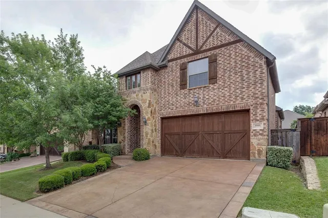 a front view of a house with a garden and garage