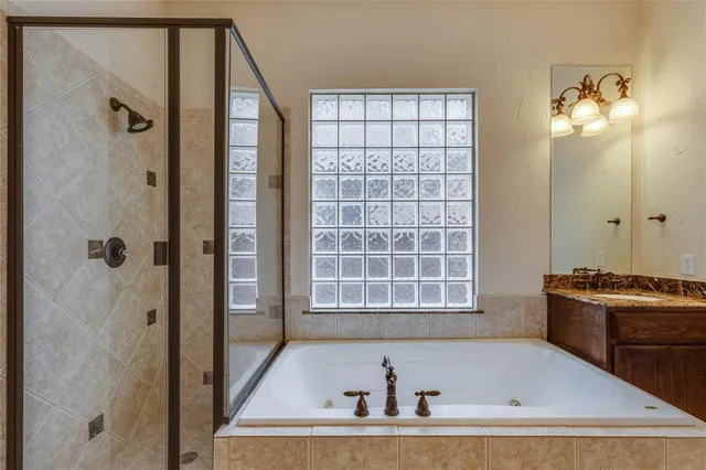 a bathroom with a tub a sink and a window