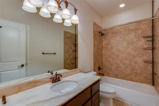 a bathroom with a sink vanity granite tub toilet and a mirror