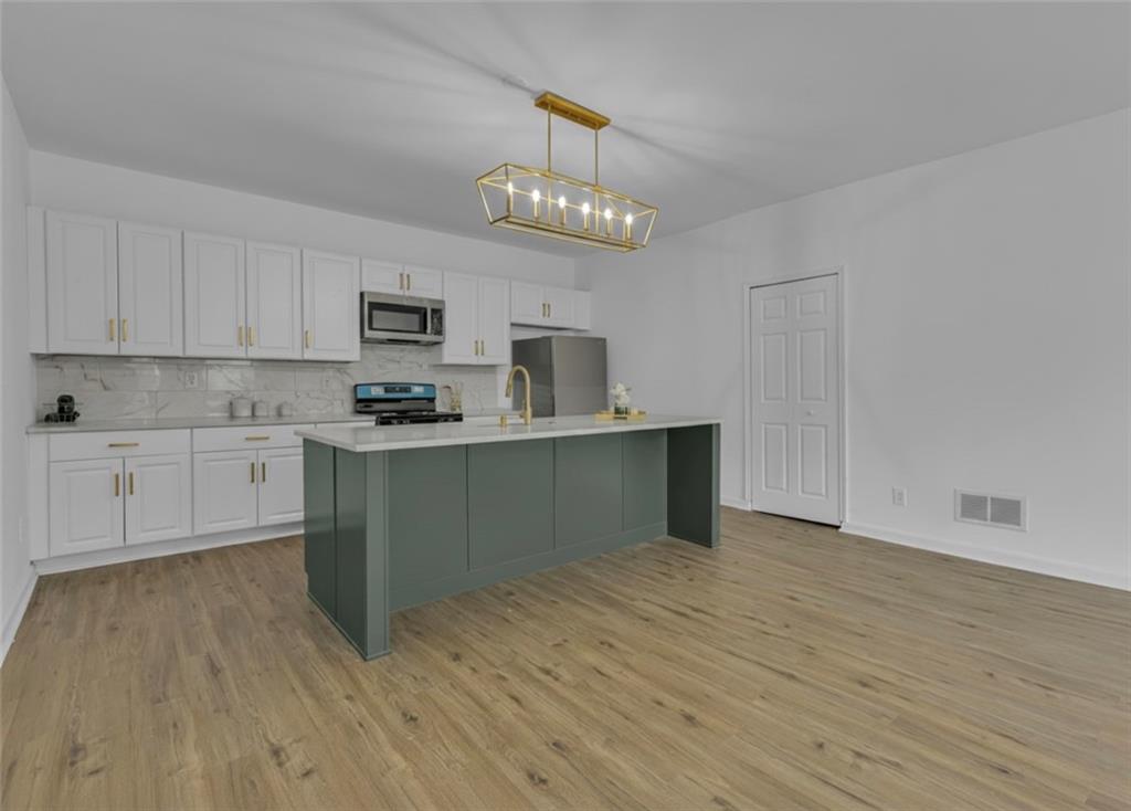 193 Virginia Avenue Rochester, PA 15074 - Photo 12 of 37 a kitchen with granite countertop a stove cabinets and wooden floor