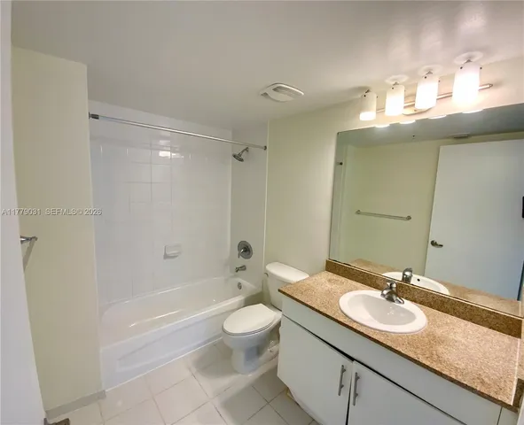 a bathroom with a granite countertop sink a toilet a mirror and shower