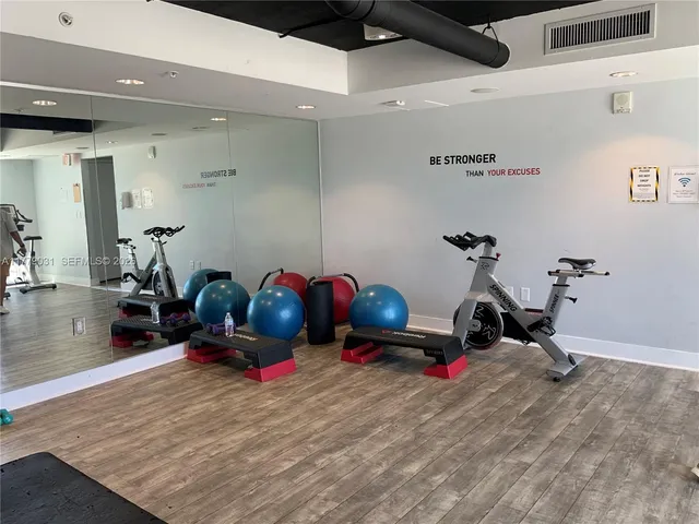 a room with gym equipment and a chandelier