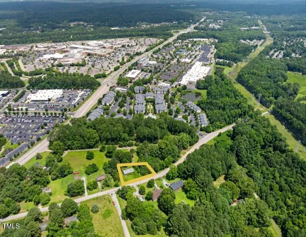 an aerial view of residential houses with outdoor space and trees