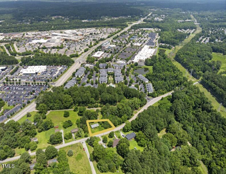 an aerial view of residential houses with outdoor space and trees