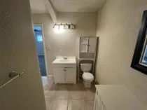 a bathroom with a granite countertop sink a toilet a mirror and shower