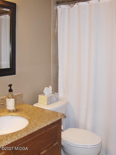 5771 Wakefield Way Macon, GA 31210 - Photo 15 of 34 a bathroom with a granite countertop sink toilet and a mirror