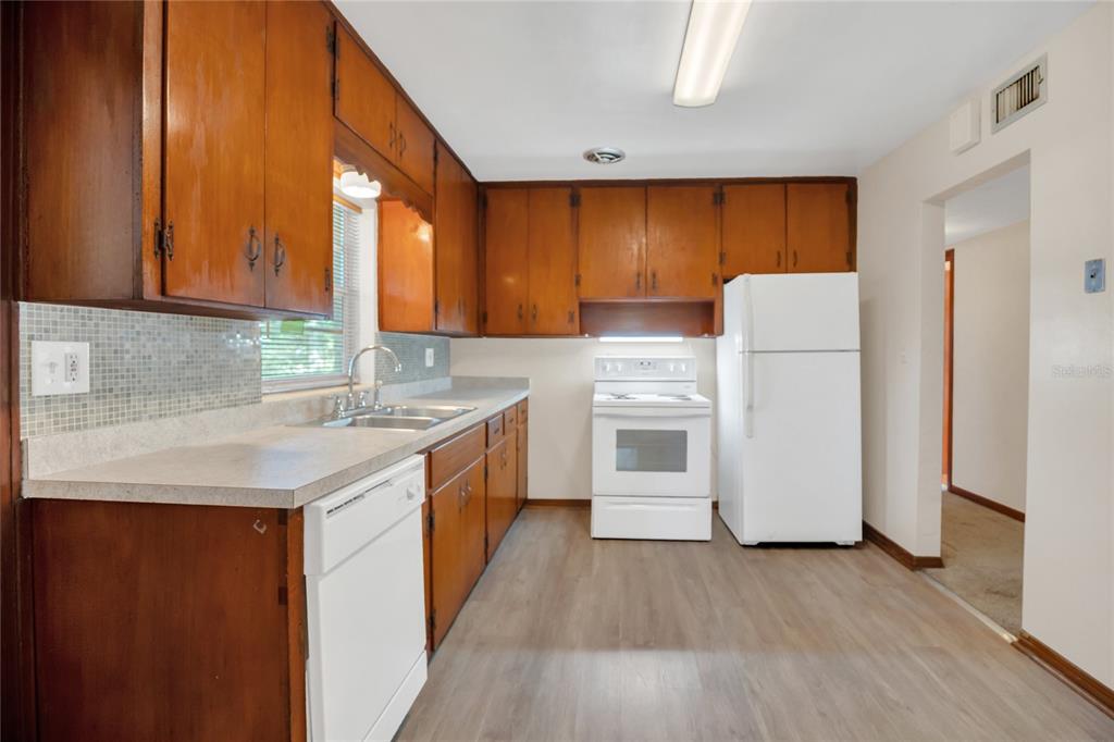 2807 Nancy Street Orlando, FL 32806 - Photo 12 of 27 a kitchen with a refrigerator a sink and dishwasher with wooden floor