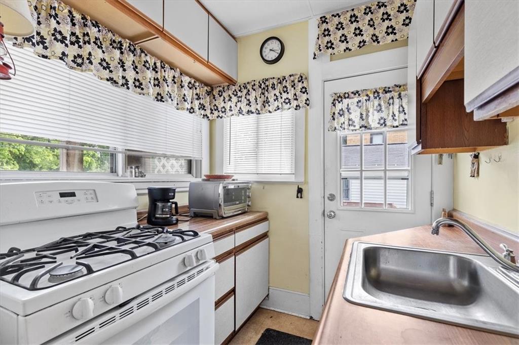115 Meade Avenue Pittsburgh, PA 15202 - Photo 15 of 27 a kitchen with stainless steel appliances a stove a sink and a microwave