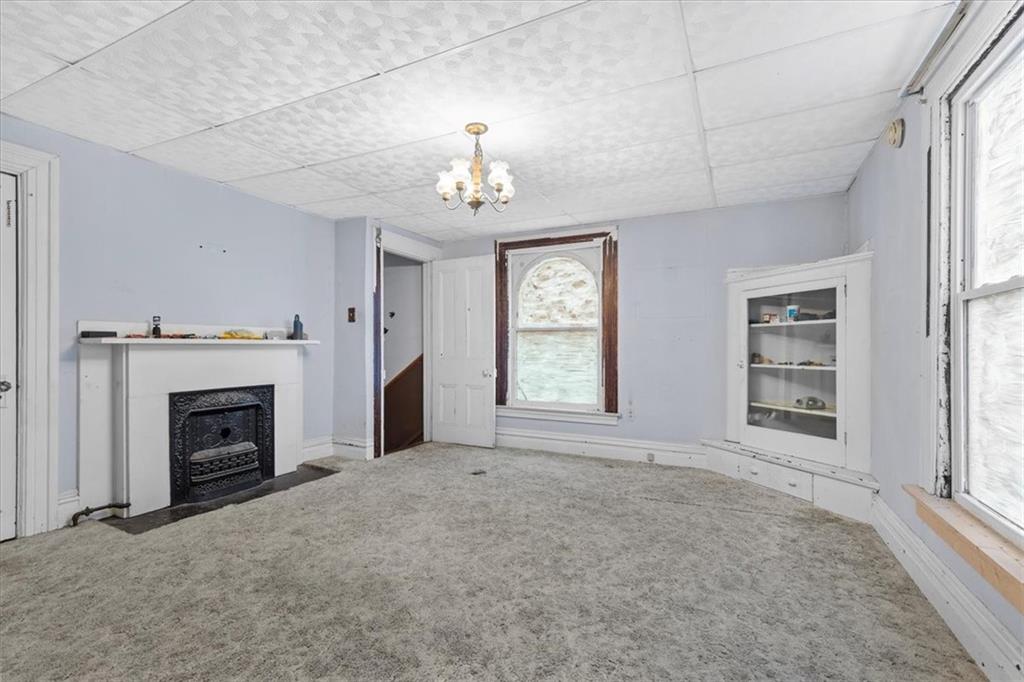 115 Meade Avenue Pittsburgh, PA 15202 - Photo 19 of 27 an empty room with windows fireplace and fans