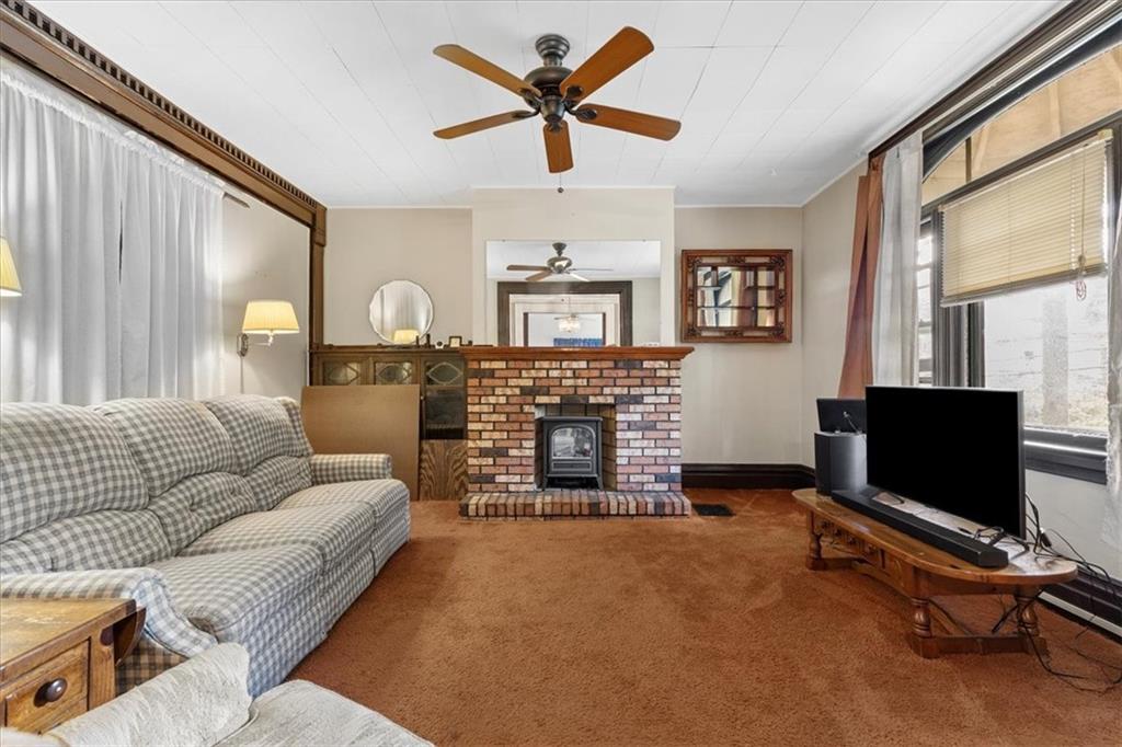 115 Meade Avenue Pittsburgh, PA 15202 - Photo 7 of 27 a living room with furniture a fireplace and a flat screen tv