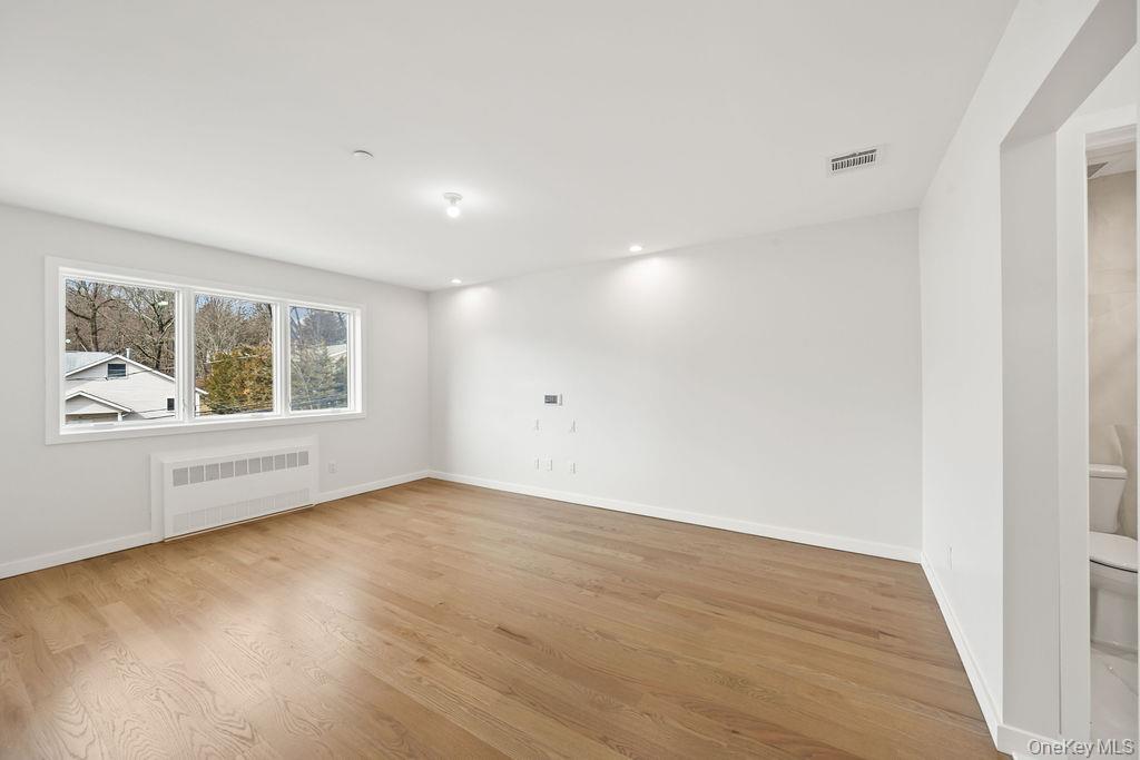 62 Blauvelt Road, Unit 202 Monsey, NY 10952 - Photo 20 of 34 an empty room with wooden floor and windows
