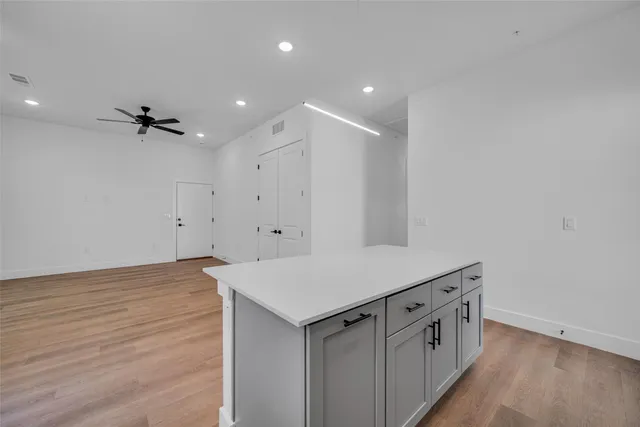 a view of an empty room with a ceiling fan and window