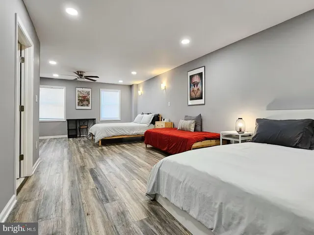 a spacious bedroom with two beds and a wooden floor