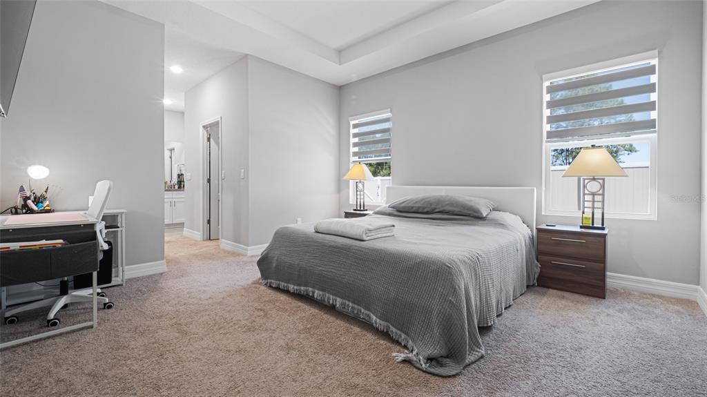 8007 Southwest 135th Loop Ocala, FL 34473 - Photo 17 of 47 a bedroom with a bed and a lamp on desk