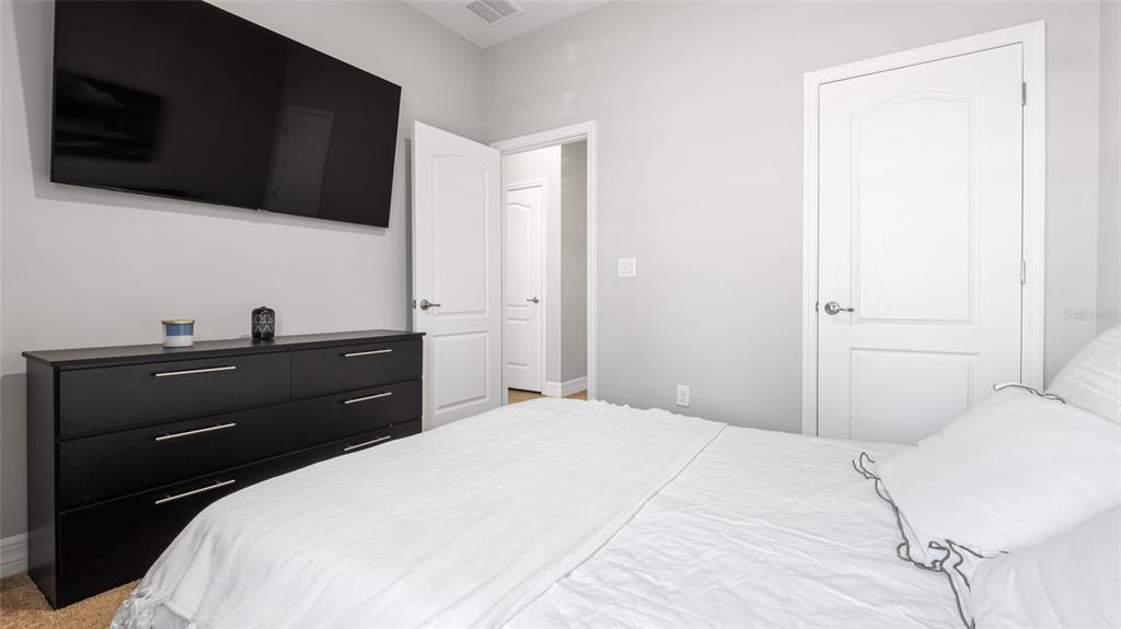 8007 Southwest 135th Loop Ocala, FL 34473 - Photo 27 of 47 a bedroom with a bed and a flat screen tv