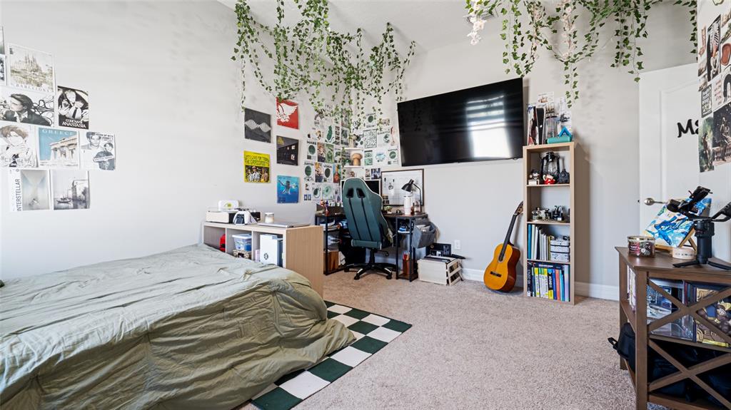 8007 Southwest 135th Loop Ocala, FL 34473 - Photo 33 of 47 a bedroom with a bed a flat screen tv and dresser