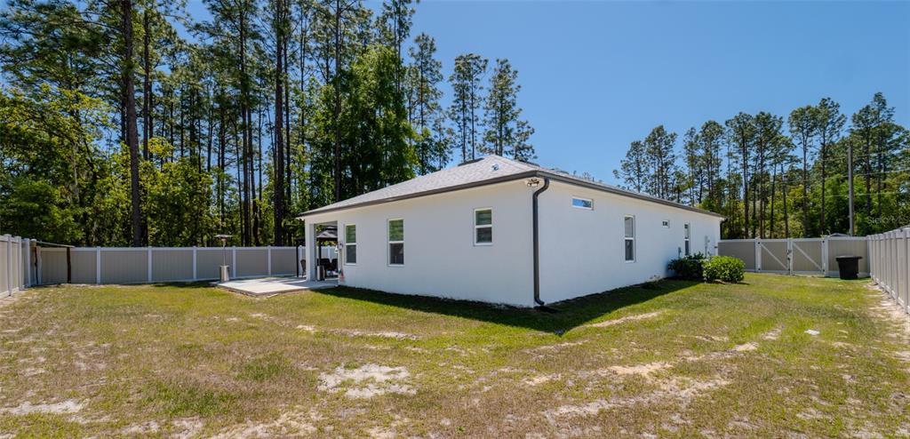 8007 Southwest 135th Loop Ocala, FL 34473 - Photo 42 of 47 a view of a house with backyard and trees in the background