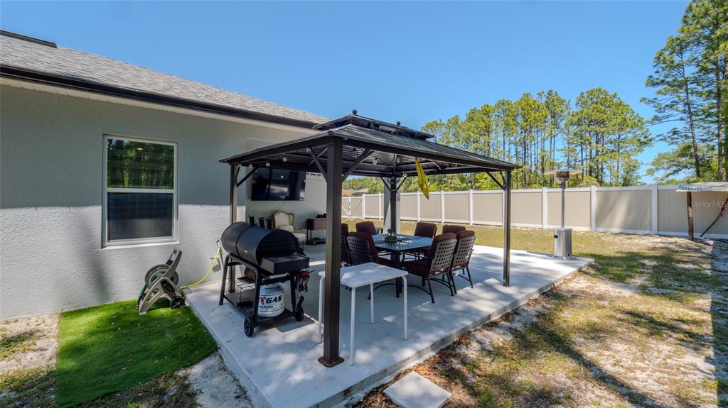 8007 Southwest 135th Loop Ocala, FL 34473 - Photo 45 of 47 a view of a patio with table and chairs and potted plants