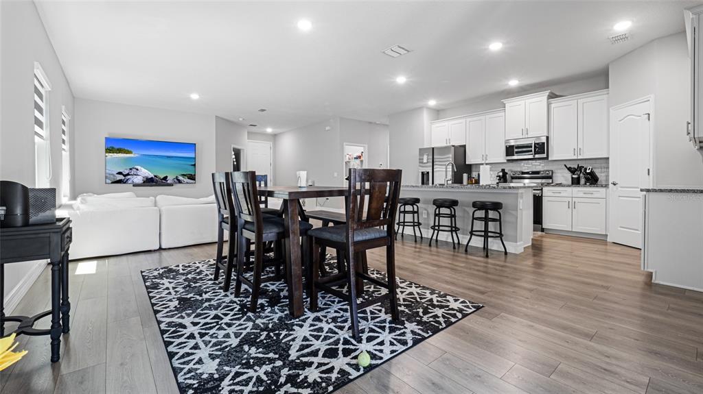 8007 Southwest 135th Loop Ocala, FL 34473 - Photo 10 of 47 a kitchen with stainless steel appliances granite countertop a dining table chairs stove and white cabinets