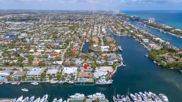 an aerial view of a city with lots of residential buildings ocean and mountain view in back