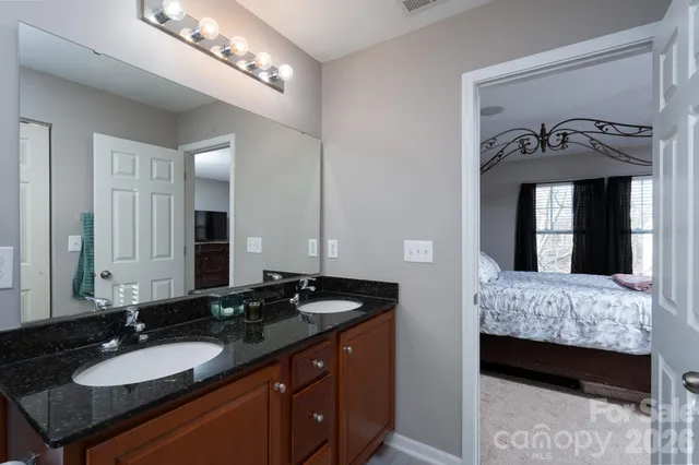 a en suite bathroom with a double vanity sink and a mirror